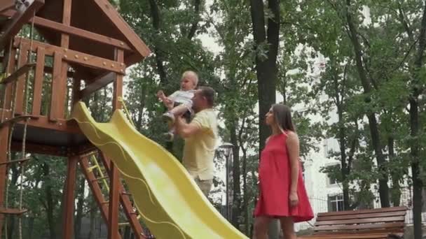 Le père met l'enfant sur un toboggan pour enfants — Video