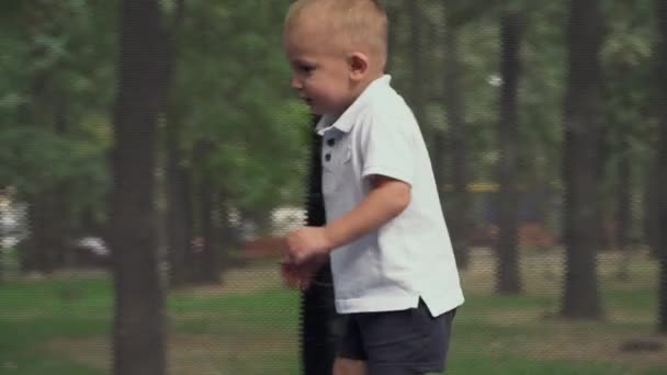 Il ragazzino sta saltando su un trampolino — Video Stock