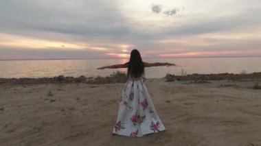 Esmer güzel bir elbise nehre doğru gidiyor. Dron'un vurdu