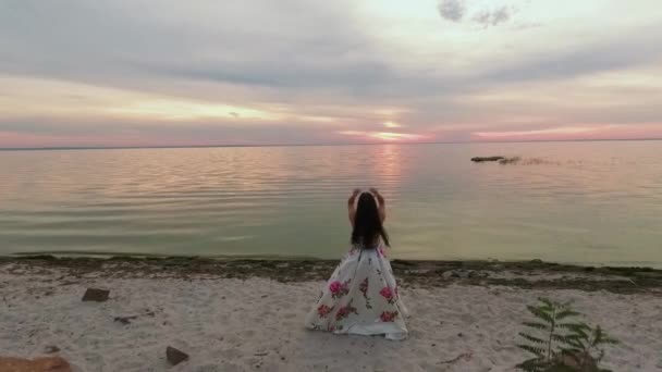 Söt kvinna med att utveckla hår på stranden av floden. Skott på drone — Stockvideo