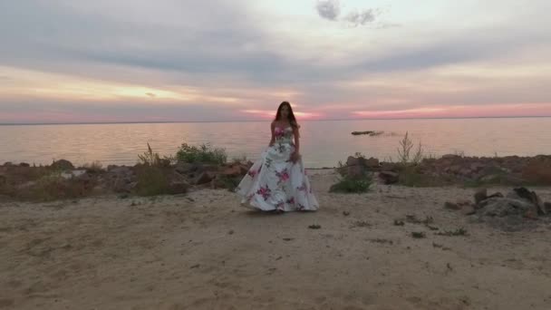 Hermosa chica en un largo vestido de noche junto al río. Disparo en dron — Vídeos de Stock