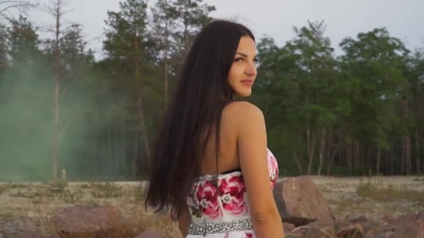 Bájos barna egy estélyi ruhában, a háttérben az erdő — Stock videók