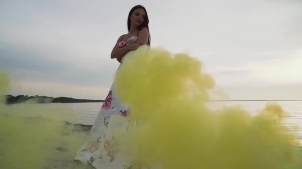 Chica joven en vestido de noche en el fondo de las bombas de humo — Vídeo de stock