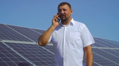 Güneş panelleri arka plan üzerinde telefonda konuşan adam