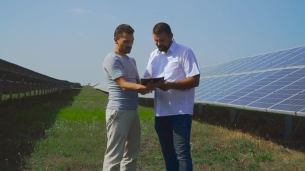 Dos empresarios están discutiendo un proyecto sobre baterías solares . — Vídeo de stock