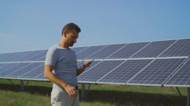 Genç adam alan güneş panelleri ile telefonda konuşurken