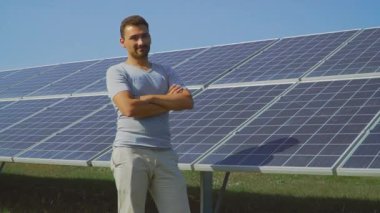 Yakışıklı adam başparmak güneş panelleri arka plan üzerinde göstermek yukarıya