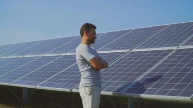 Genç adam başparmak güneş panelleri arka plan üzerinde göstermek yukarıya