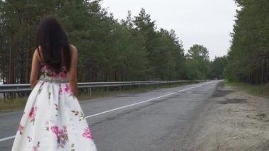 Akşam elbiseli çekici kız açık havada yolda yürüyor