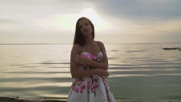 Нежная девушка в красивом длинном платье на реке — стоковое видео
