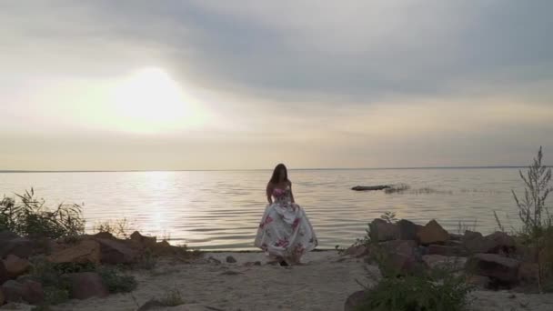 Linda chica en un vestido largo en una hermosa playa — Vídeo de stock