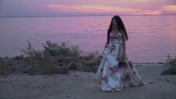 Красива леді в довгій сукні на красивому пляжі — стокове відео
