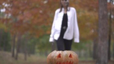 Cadılar Bayramı. Kız bir kabak için geliyor bir kasap bıçağı ile