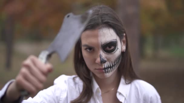 Хэллоуин. Девушка с мертвецом макияж держит нож — стоковое видео