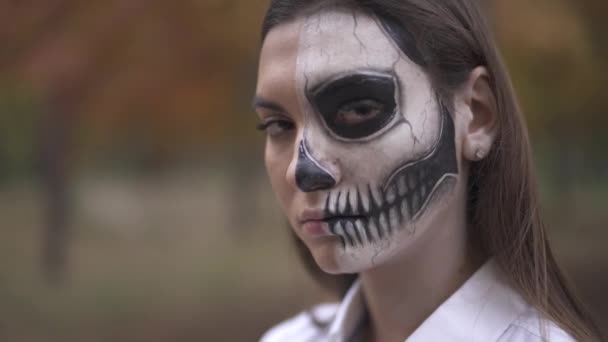 Dia das Bruxas. Menina com maquiagem Halloween corre o dedo ao longo da lâmina de faca — Vídeo de Stock