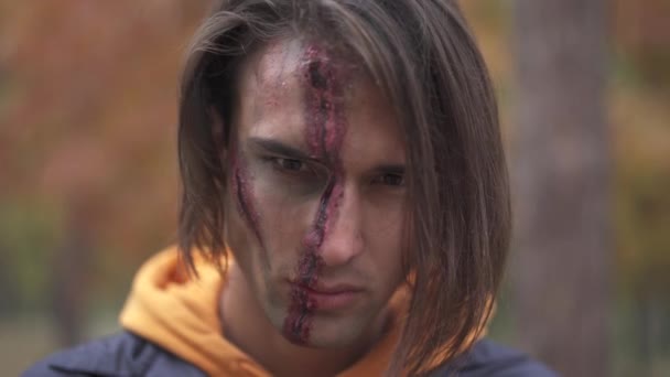 Halloween. Leende kille med med en olycksbådande make-up. — Stockvideo