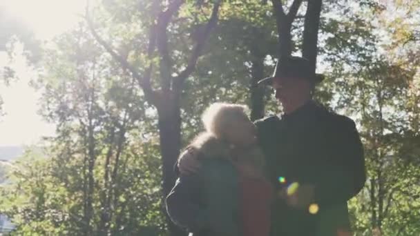 Oude paar wandelingen in de zon in het park. — Stockvideo