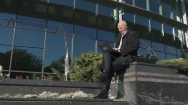 Yaşlı adam şehir içinde laptop ile çalışma