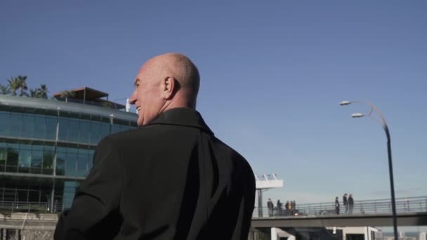 Vysoký zralý muž se dívá na moderrn budovy — Stock video