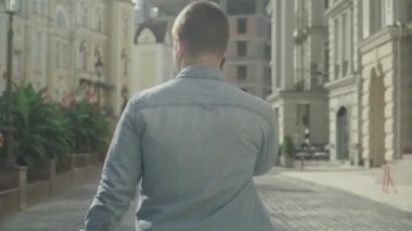 Genç adam yürür kamera ve telefon görüşmeleri