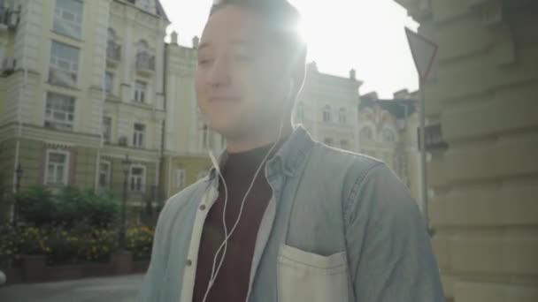 Молодой человек в наушниках любит музыку — стоковое видео