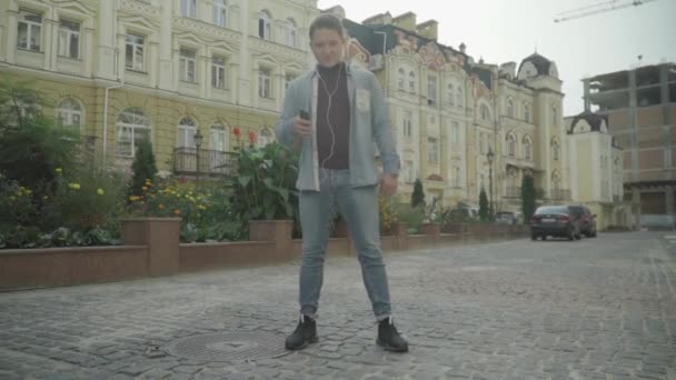 Молодой человек в наушниках любит музыку — стоковое видео