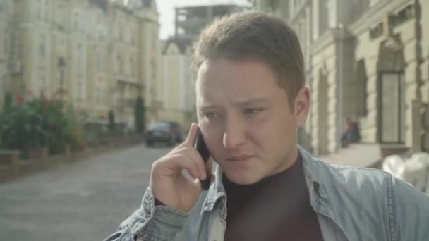Νεαρός άνδρας μιλάει στο τηλέφωνο. Προσώπου, κοντινό πλάνο — Αρχείο Βίντεο