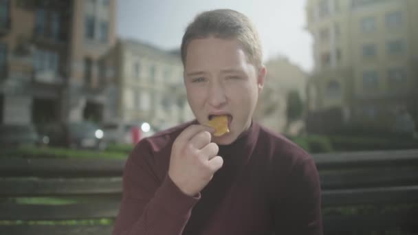 Joven come patatas fritas — Vídeos de Stock