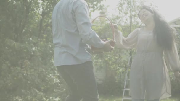Casal adulto alegre com uma cesta no pomar de fruto — Vídeo de Stock