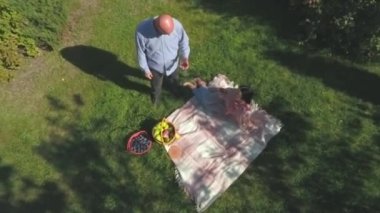 Yaşlı adam ve kadın öğle yemeği açık. Drone vurdu.