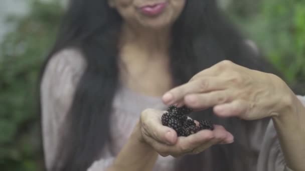 Açık havada meyveleri yemekten büyüleyici yaşlı kadın — Stok video