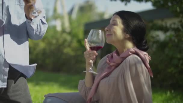Зрелая женщина пьет вино на открытом воздухе — стоковое видео