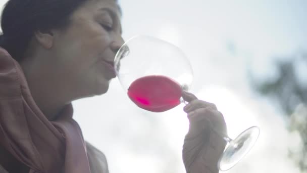 Retrato de una mujer madura con una copa de vino al aire libre. Primer plano — Vídeo de stock