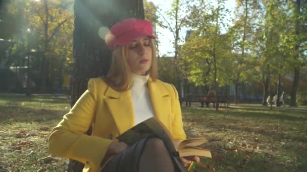 Elegante dama está leyendo libro en el parque — Vídeos de Stock