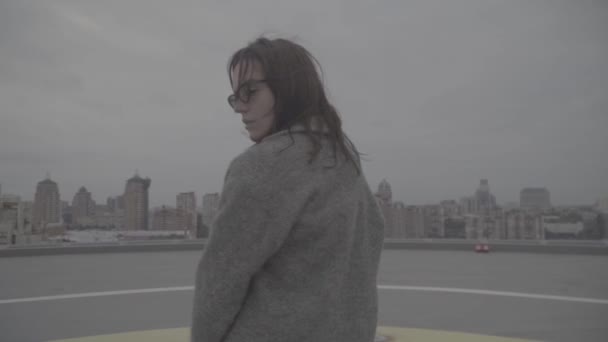 Nice girl goes on the background of the city view. Slow motion, s-log, ungraded — Stock Video