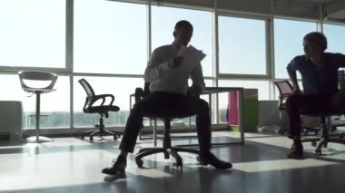 Ofis çalışanı bir sandalyede meslektaşım ve atmak gazetelere kadar sürdü