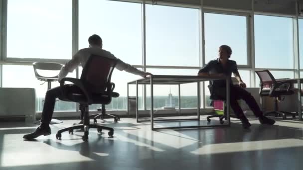 Employé de bureau conduit dans un fauteuil à un collègue — Video