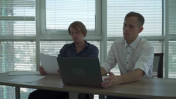 Dos trabajadores de oficina discuten netbook formulario de información — Vídeo de stock