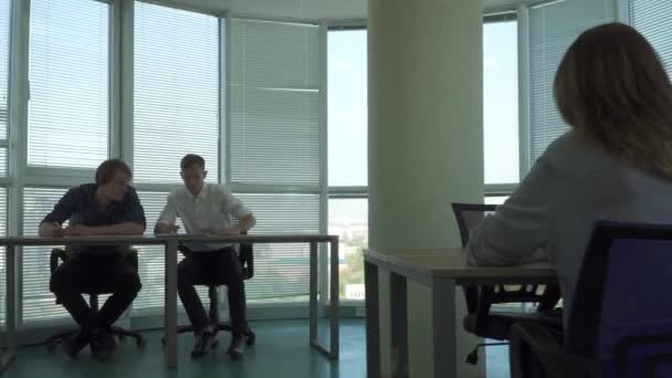 Két srác és egy lány egy szép irodában dolgozik — Stock videók