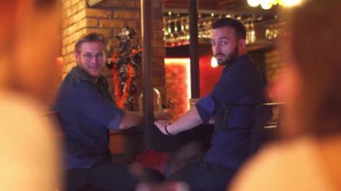 İki arkadaş barda oturan'de iki kız ilgilenmeye başladı.