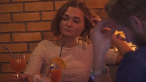Jovencita está aburrida sentada con un chico en la mesa — Vídeos de Stock