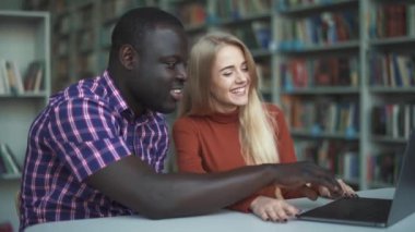 Avrupa kadın ve Afrikalı-Amerikalı gülüyor ve laptop arıyorum