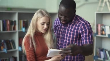 Afrika kökenli Amerikalı adam ve Avrupa Bayan kütüphanede kitap lanetleme