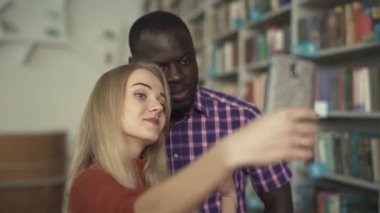 Afrika kökenli Amerikalı adam ve Avrupa Bayan selfie kütüphanede yerim