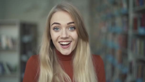 Jonge vrouw is glimlachend in de camera — Stockvideo