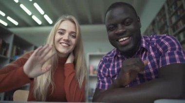Kız ve Afro-Amerikan arkadaşı kamera veda sallıyor