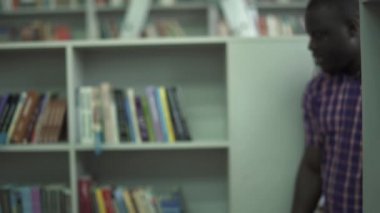 Avrupa kadın ve Afrika kökenli Amerikalı adam bookshelf konuşuyor