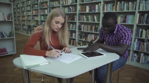 Afrických amerických mužů a Evropské ženské podepisovat dokumenty na stole — Stock video