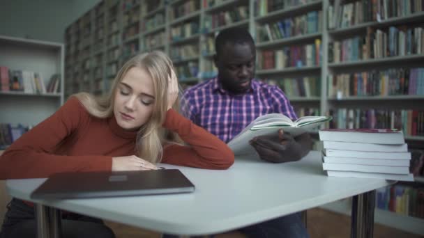 African american man och Europeiska kvinna somnar i biblioteket — Stockvideo