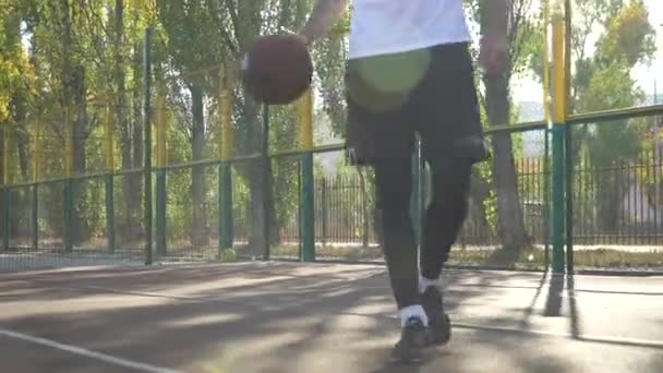 Hombre adulto está entrenando habilidades de baloncesto al aire libre — Vídeos de Stock